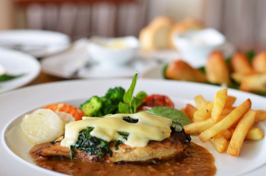 Grilled chicken steak served with chips, potatoes and vegetables