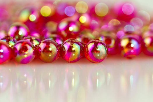 red beads on white surface with mirror image