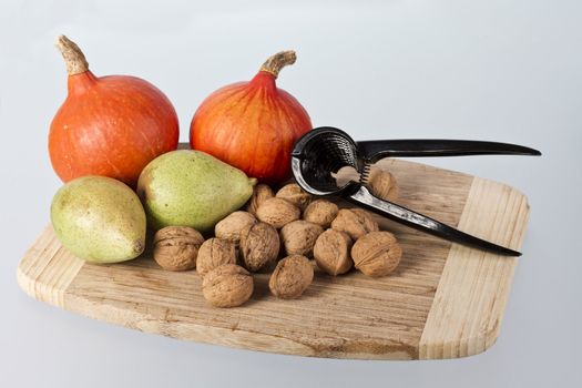 pear, pumpkin and many nuts isolated on white background with nutcracker