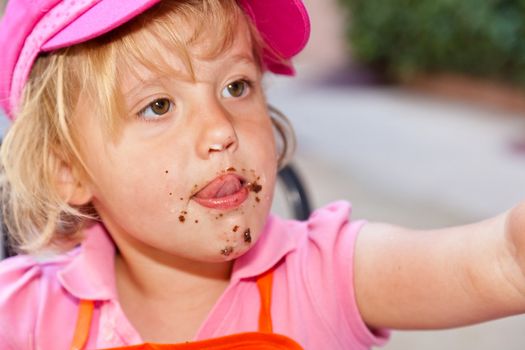 Eating a delicious chocolate cupcake with chocolate frosting.