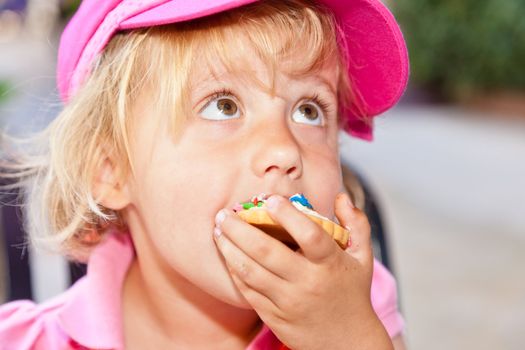 Eating a delicious cookie with cream frosting.