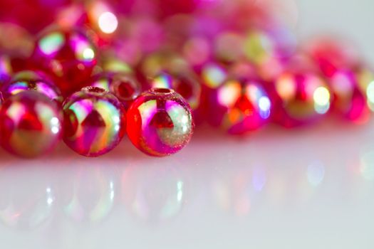 red beads on white surface with mirror image