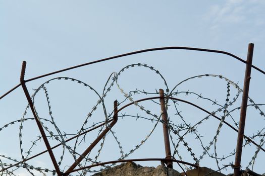 the barbed wire on a high fence 