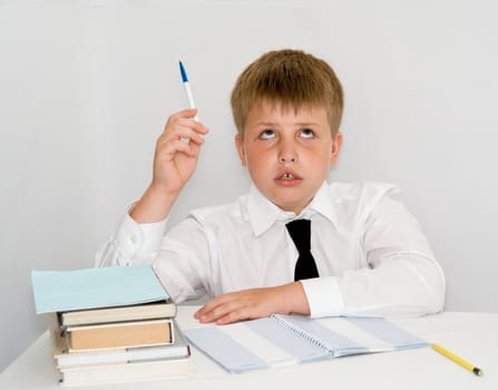 Schoolboy with his hand raised ready to answer a question