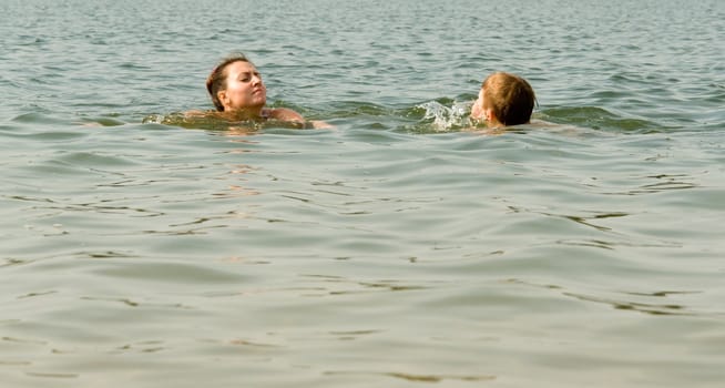 Mom and son swimming in the sea