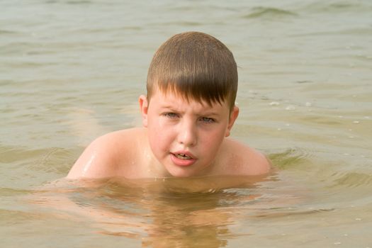 the little boy swims in the sea