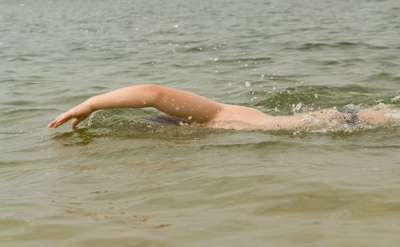 the little boy quickly swims the crawl