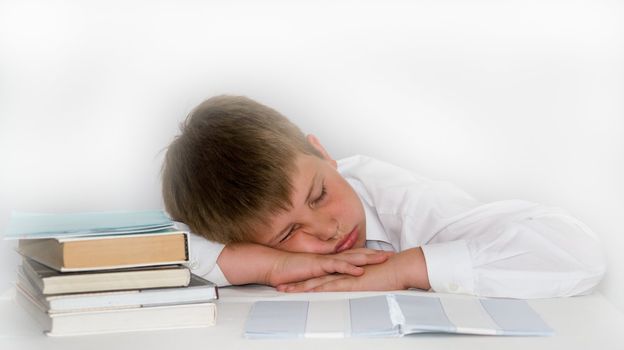 a young boy studying his homework. boy sleeps