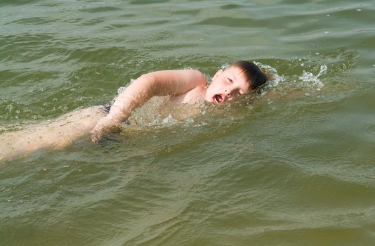the little boy quickly swims the crawl