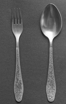 dinner fork and spoon on a grey background