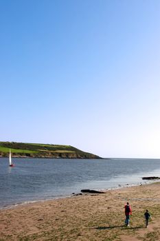 a father and son walking on the beach in youghal harbor ireland