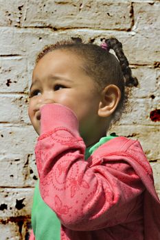 Young black baby girl playing in an alley