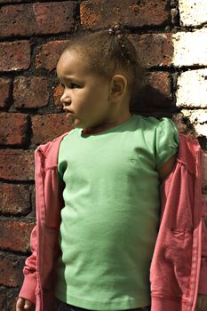 Young black baby girl playing in an alley