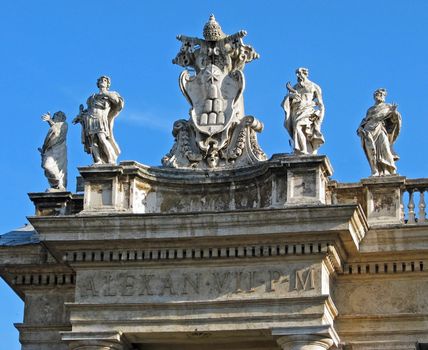 Statues and the coat of arms of Pope Alexander VII atop St. Peter's Square in Rome.
