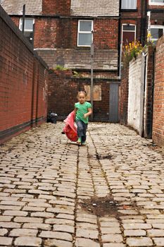 Young black baby girl playing on cobble stoned alley