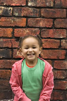 Young black baby girl playing in an alley