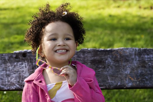 Young black baby girl with glasses smiling