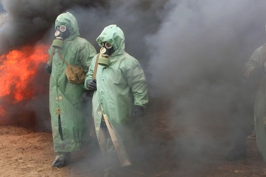 Two soldiers in chemical protection suites.