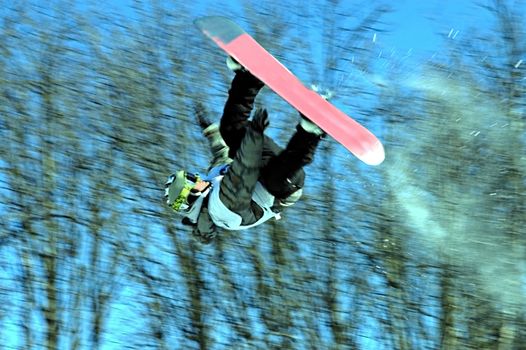 A snowboarder going big high above the half pipe                                      