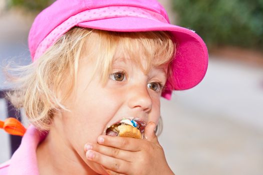 Eating a delicious cookie with cream frosting.