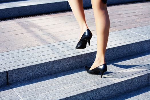 Businesswoman taking step to higher level on stairway