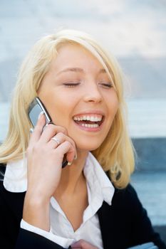 Young businesswoman sitting on stairway, using cell phone