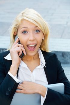 Young businesswoman sitting on stairway, using cell phone