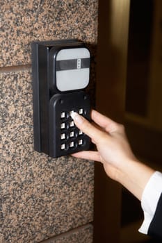 Hand of young businesswoman, entering access code