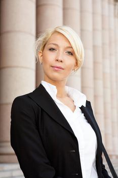 Portrait of young businesswoman outside building, looking at camera