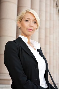 Portrait of young businesswoman outside building, looking at camera