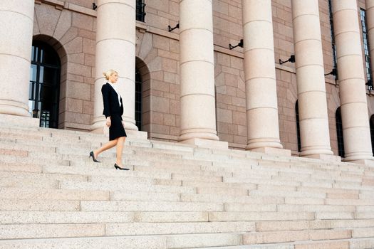 Businesswoman walking down the stairs of building