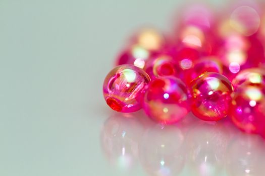 red beads on white surface with mirror image