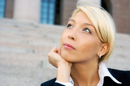 Businesswoman sitting outside building contemplating, close-up