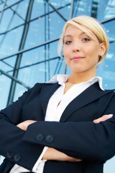 Young businesswoman arms crossed, looking at camera