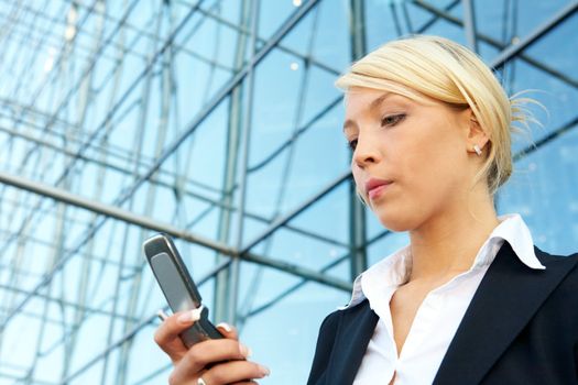 Young businesswoman holding mobile phone, low angle view