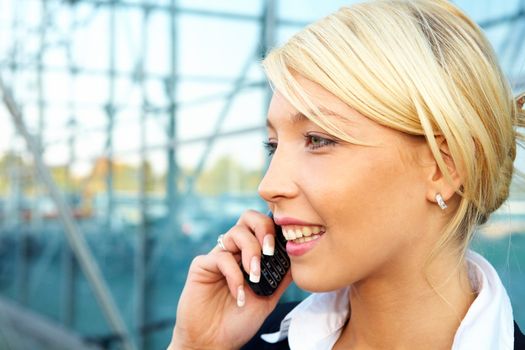 Young businesswoman using mobile phone, smiling