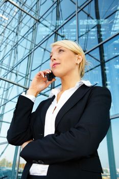 Young businesswoman using mobile phone, looking up