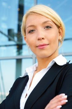 Yong businesswoman looking at camera, arms crossed