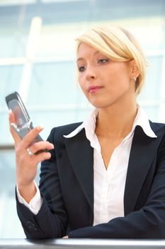 Businesswoman looking at mobile phone, low angle view