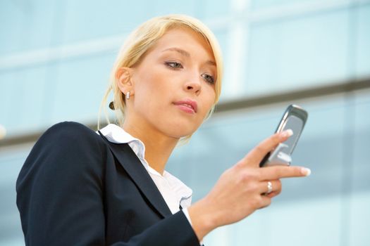 Businesswoman text messaging with mobile phone