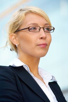 Young businesswoman contemplating outside office building, close-up