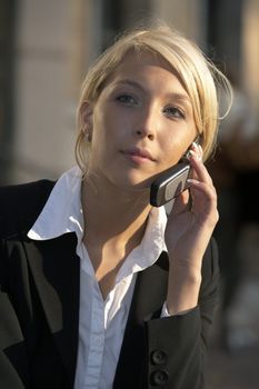 Close-up of young businesswoman using mobile phone in street