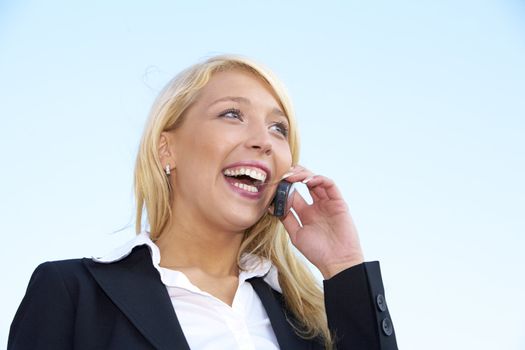 Young businesswoman laughing while using mobile phone