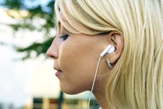 Close-up of young businesswoman wearing earphones