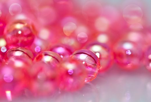 Red beads on white surface with mirror image