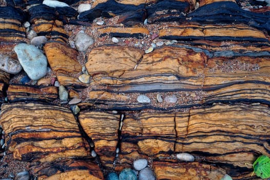 Natural stone structure and smallish pebbles between cracked
