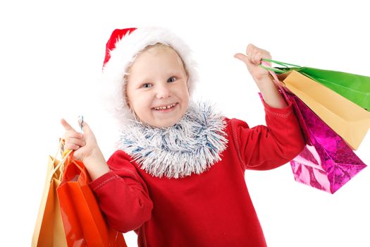 child in Santas cap with presents in bags
