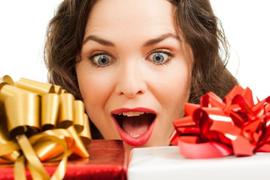 Beautiful young surprised woman looking at beautifully wrapped Christmas gifts