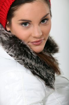 Pretty young woman wearing coat with fur