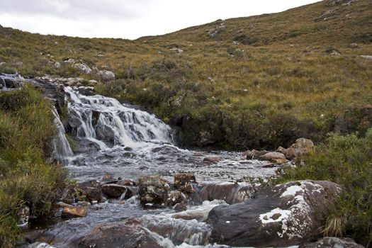 small river in scottish highlands flowing through heathland